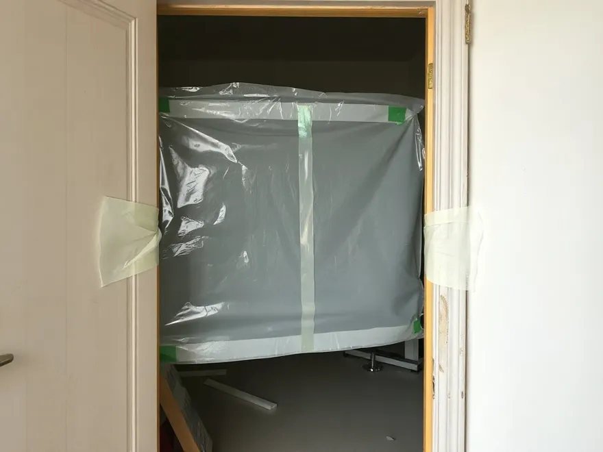 Plastic sheeting taped across a doorway sealing off a room